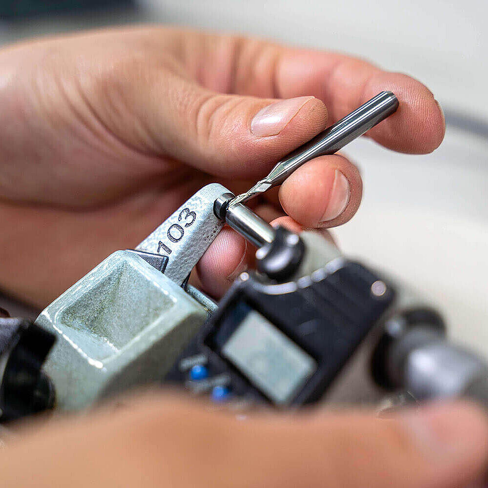 Die Dicke eines acurata Bohrers wird mit einem Messinstrument überprüft.